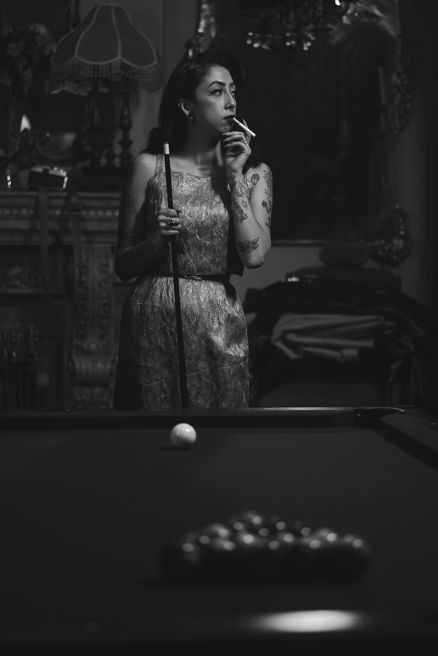 A black and white photo series showing someone playing pool in dramatic lighting.
