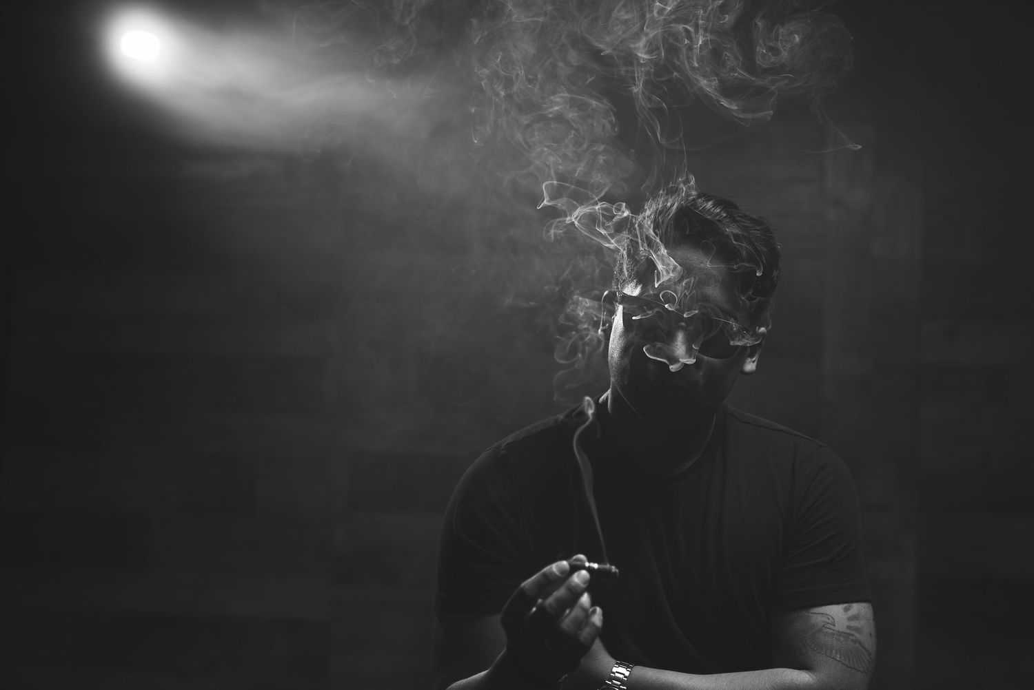 Artistic black and white portrait with smoke swirling in dramatic lighting.