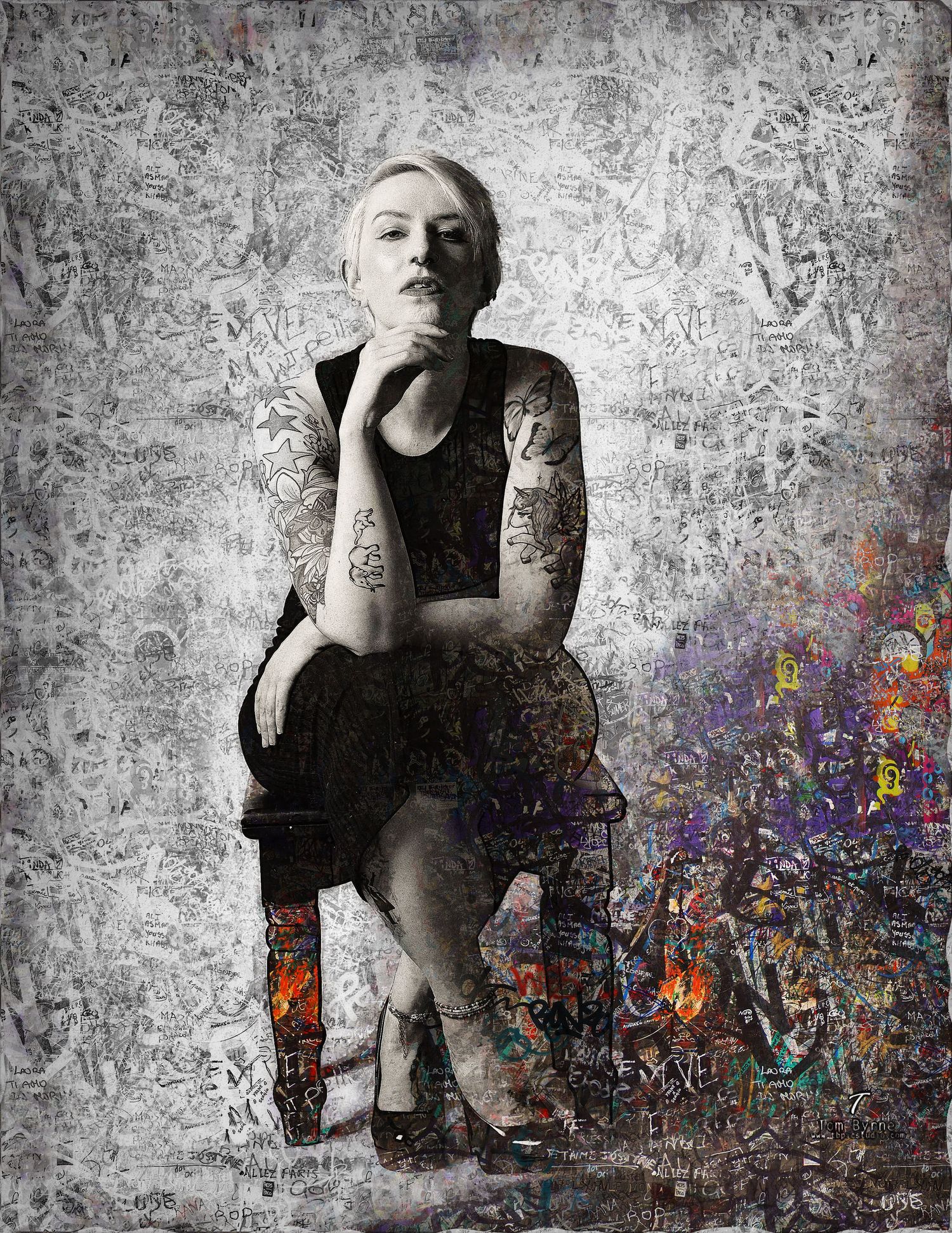 Tattooed woman in black dress seated against graffiti-covered background with colorful abstract art elements.