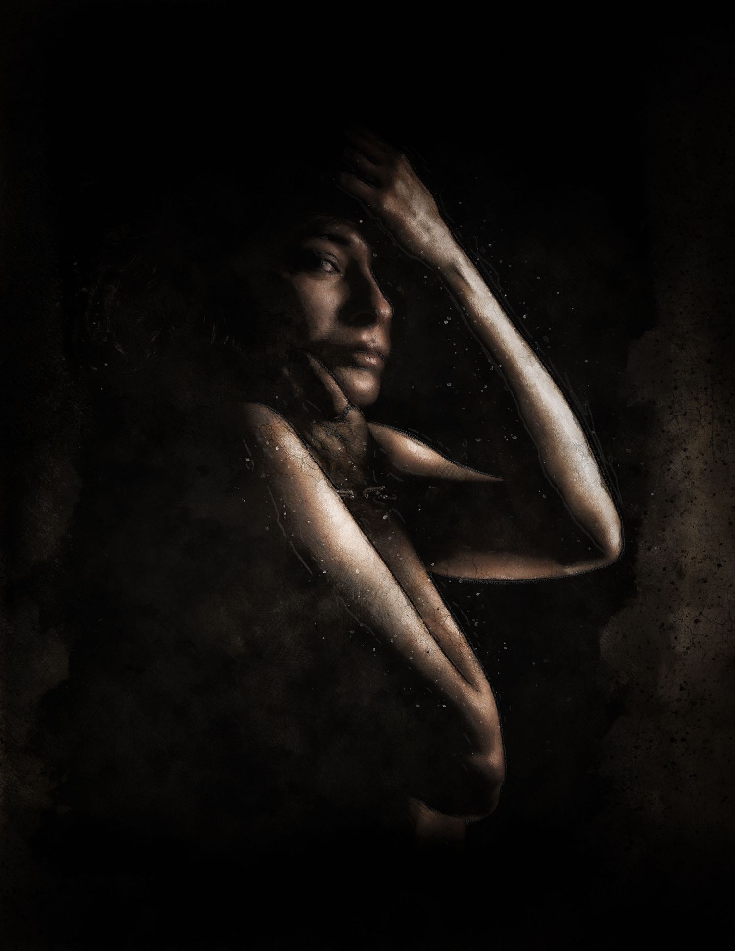 Dramatic fine art portrait of a woman emerging from dark shadows with hands raised, featuring moody chiaroscuro lighting.