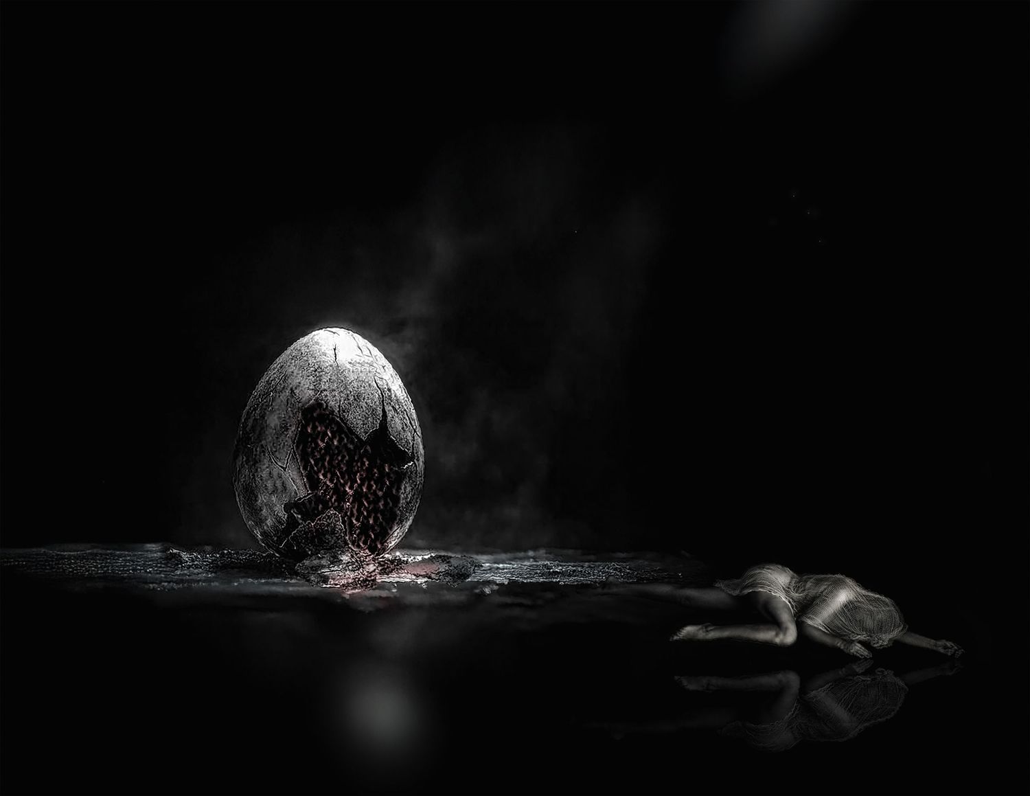 Dark atmospheric image of a cracked glowing egg emitting smoke beside a small creature on a reflective surface.