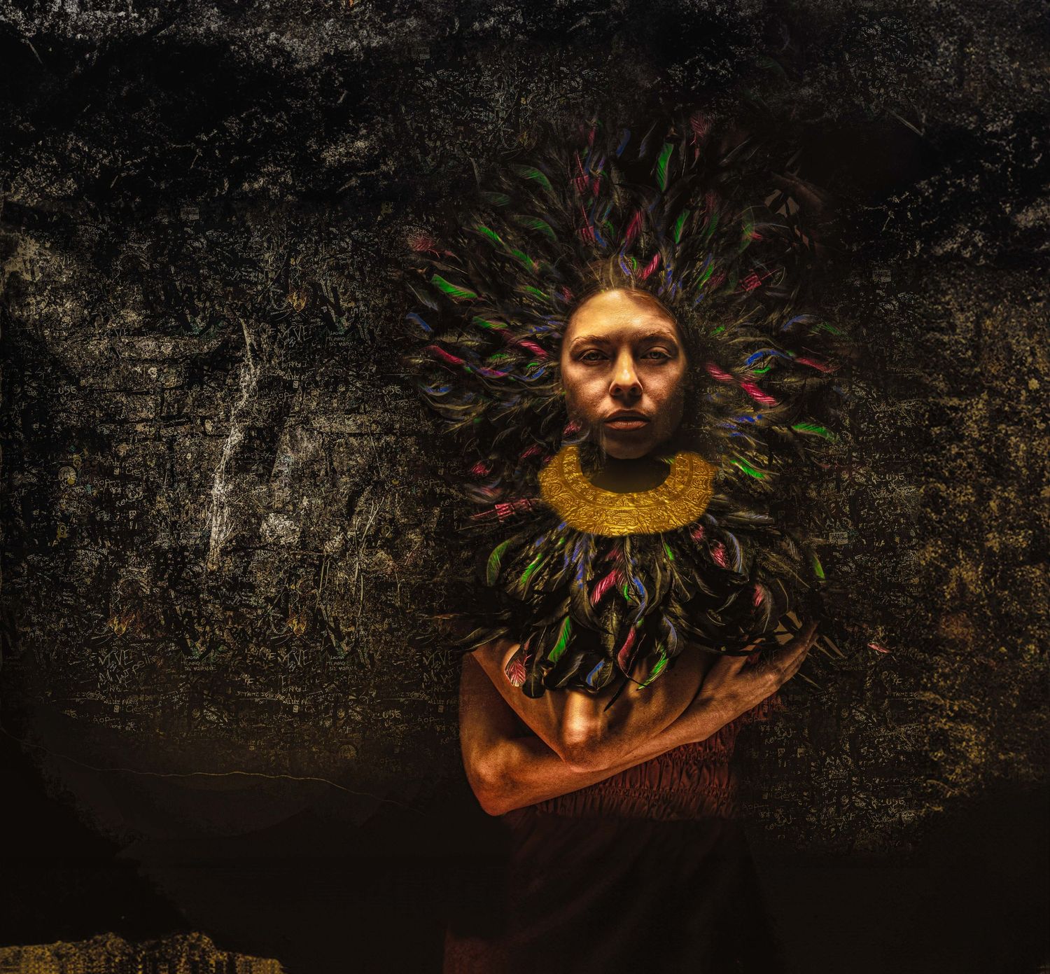 Person wearing colorful feathered headdress and yellow beaded collar against dark textured background.
