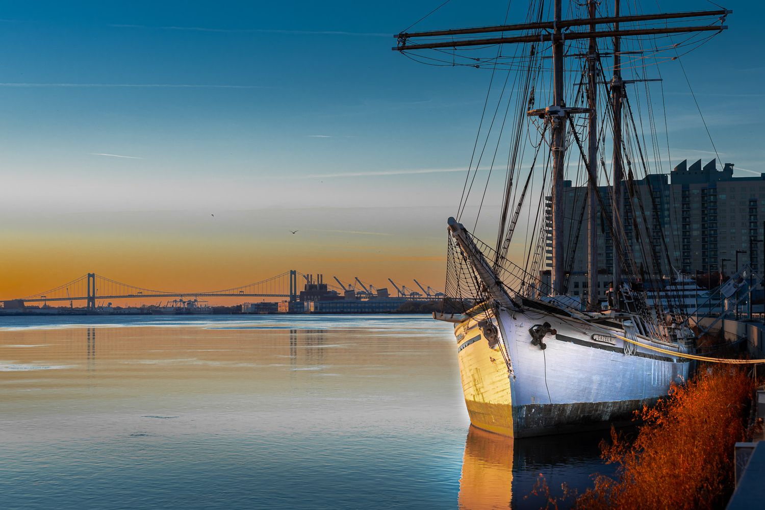 Tall ship at dawn on the Delaware River with the Walt Whitman Bridge in the background