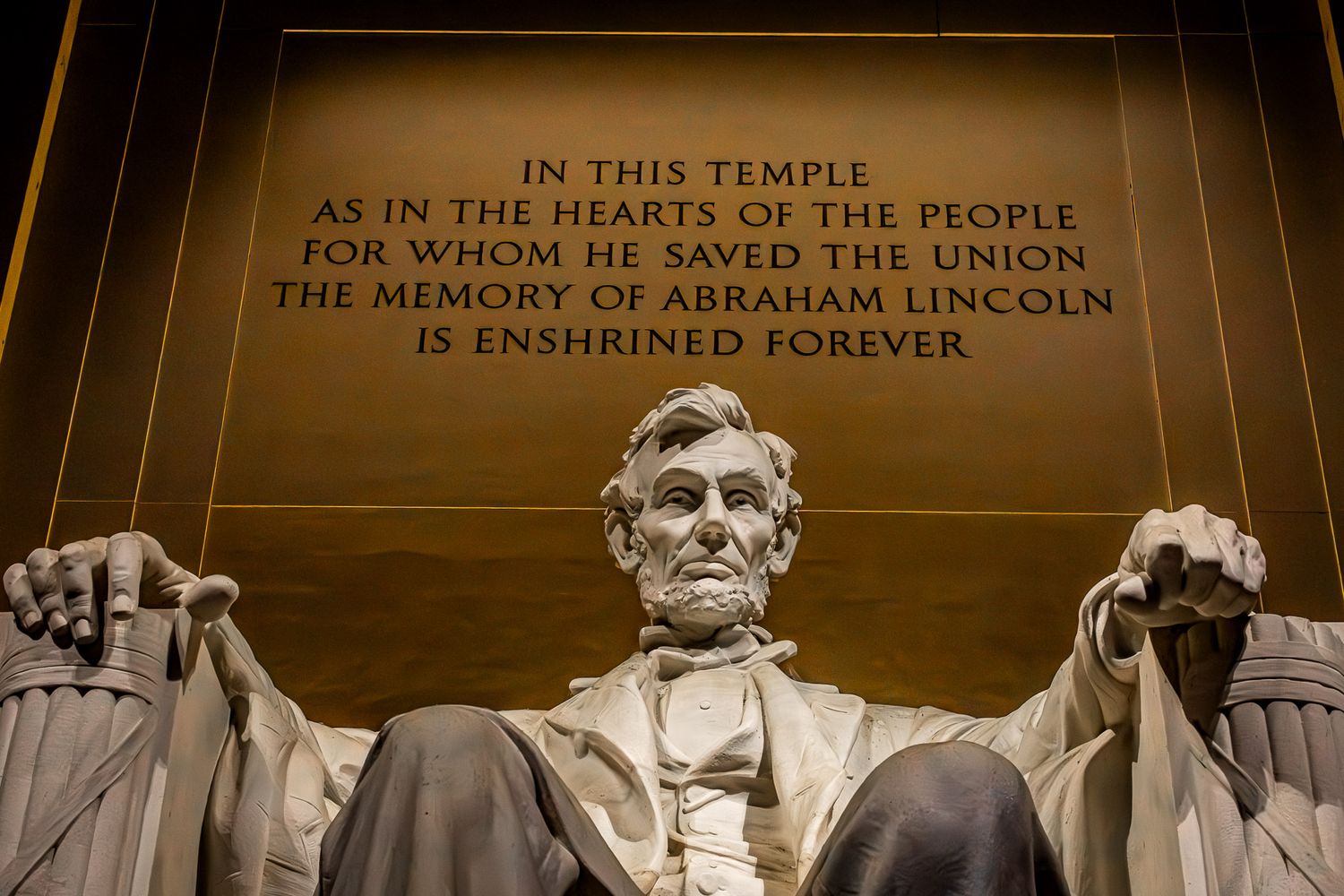 Statue of Abraham Lincoln seated inside the Lincoln Memorial with engraved inscription visible in Washington, DC.