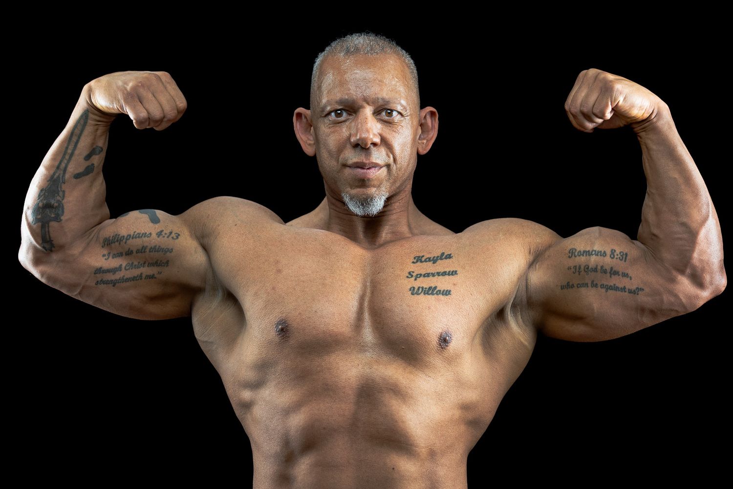 Studio portrait of muscular man flexing arms against black background during a Unique Photo photography event in New Jersey