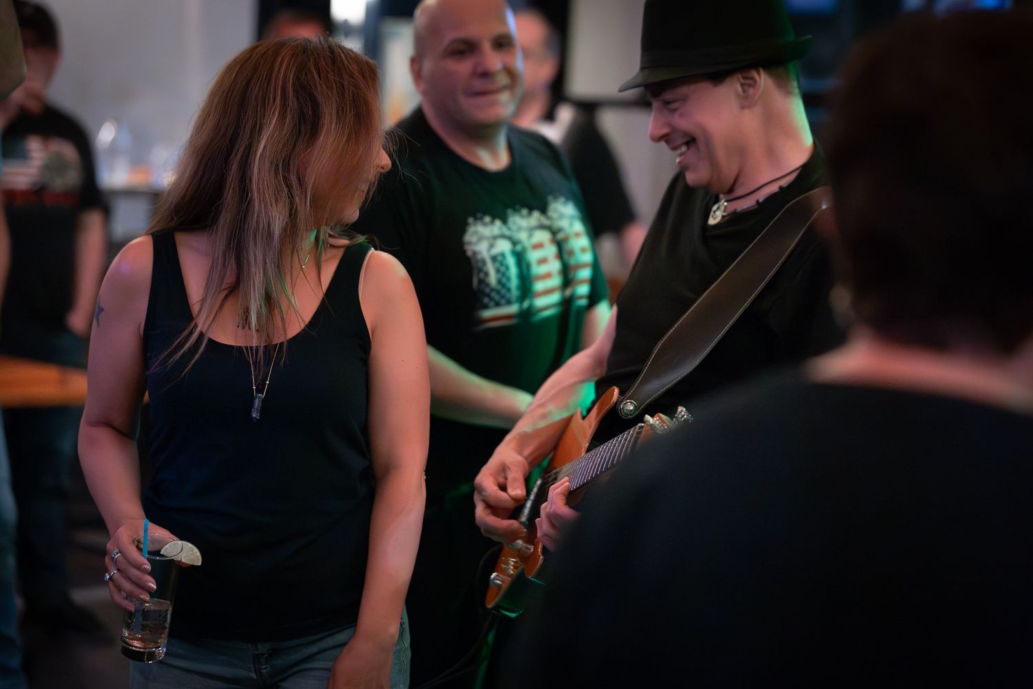 The Wrecks guitarist smiling and playing electric guitar while interacting with the crowd during a live performance.