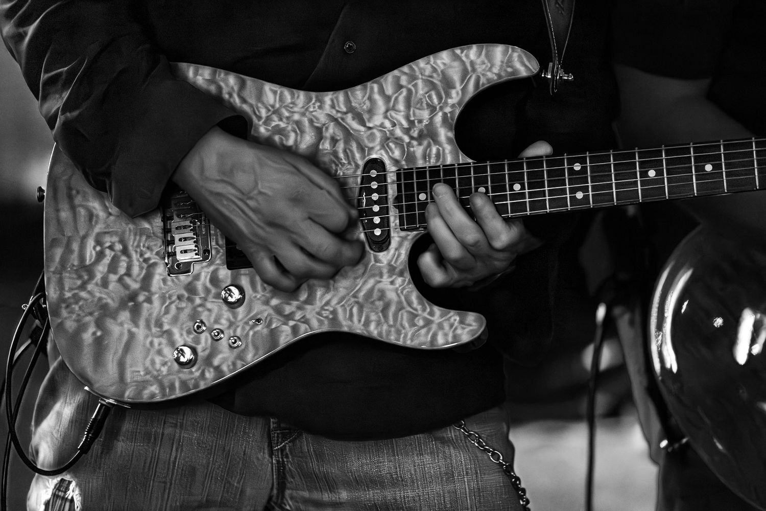 Close-up black and white photo of a guitarist performing live with The Wrecks.