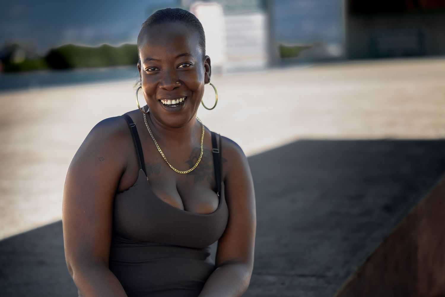 Smiling woman in Placencia, Belize, photographed outdoors in natural light, candid street portrait capturing warmth and personality.