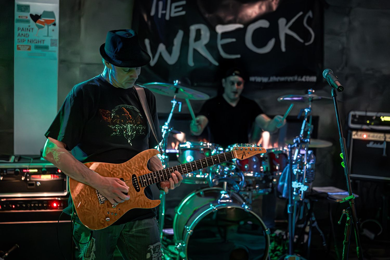 Live performance by The Wrecks featuring guitarist and drummer on stage.