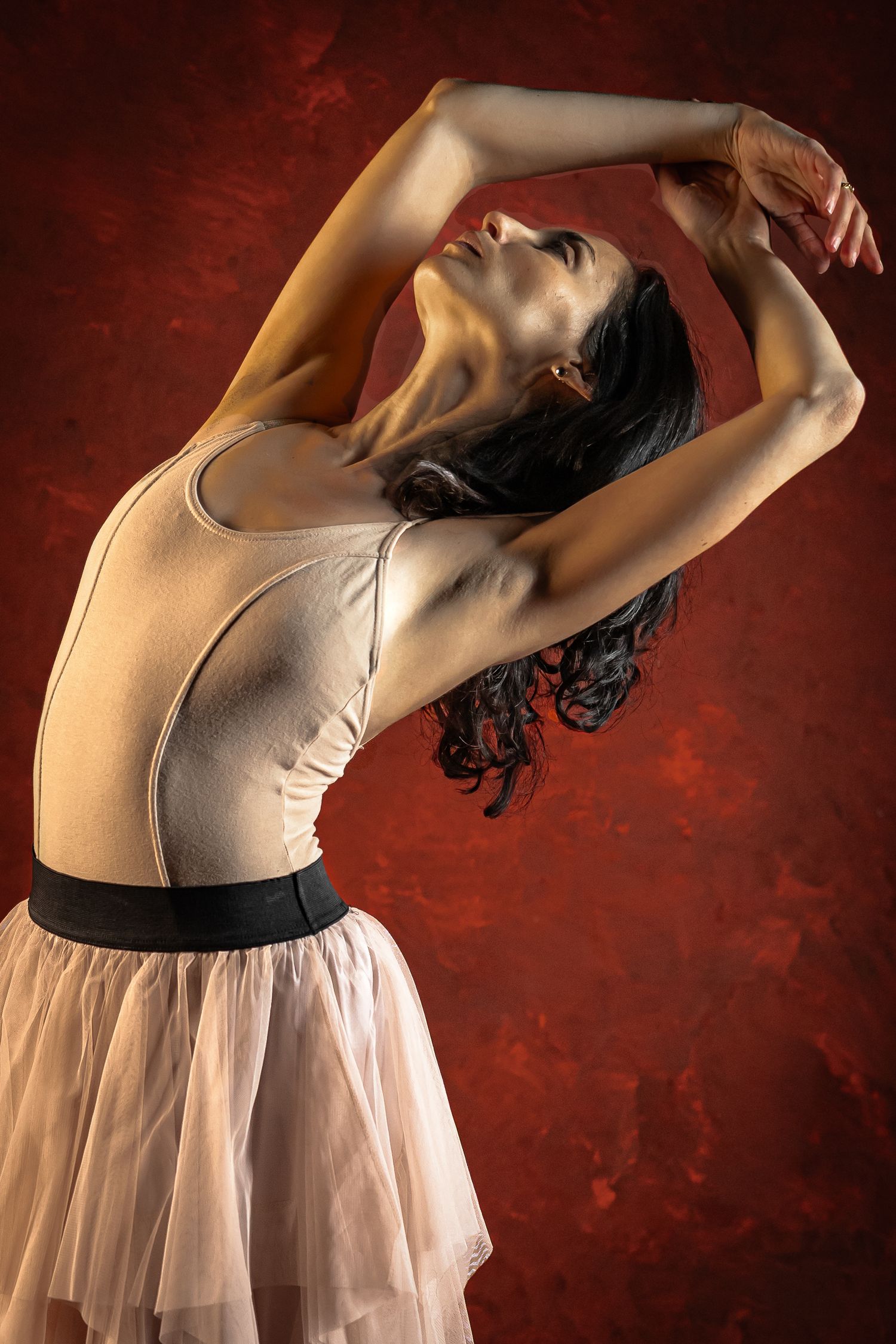 Studio portrait of a ballet dancer in an expressive arched pose against a textured backdrop in Fairfield, New Jersey.