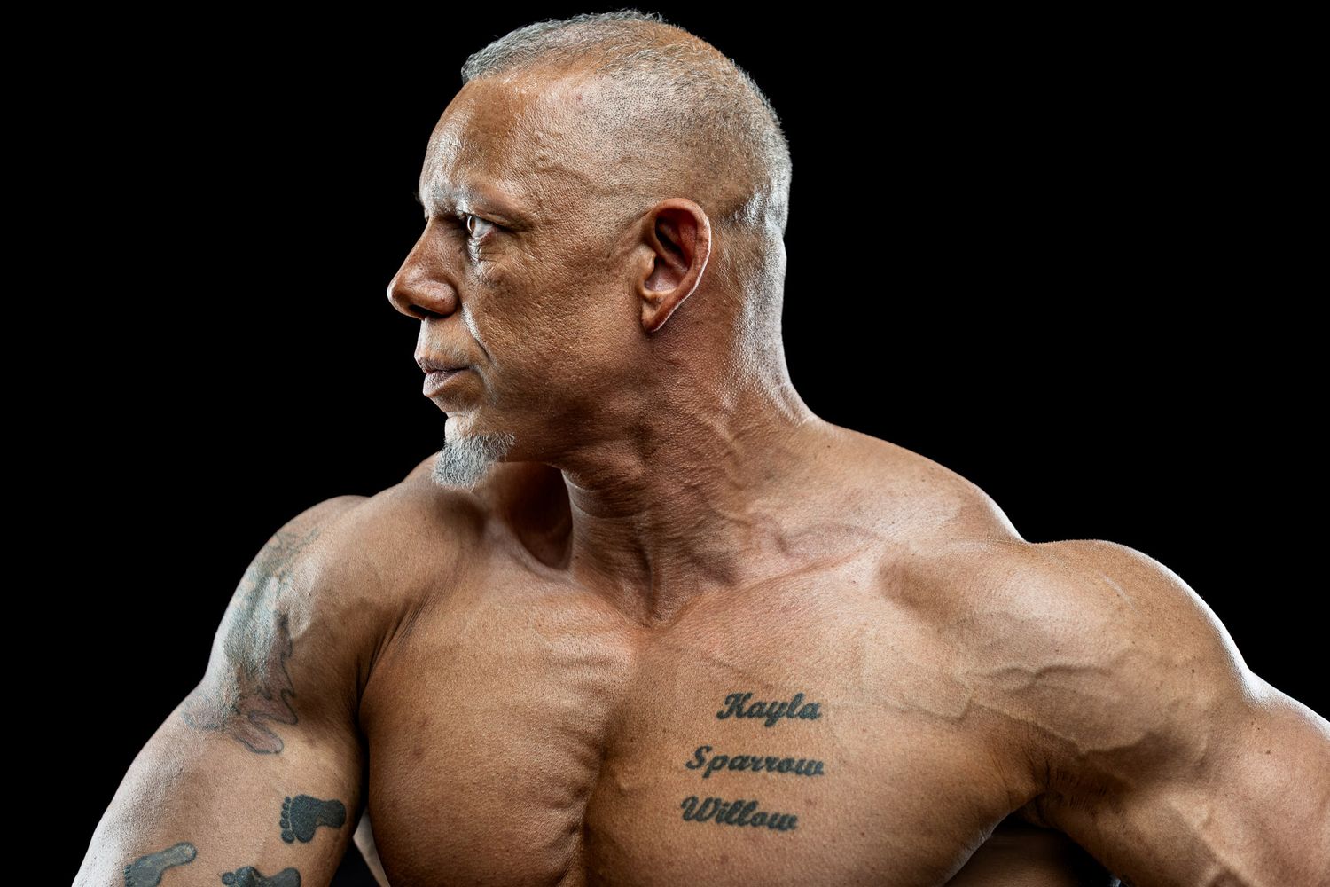 Studio portrait of muscular man in profile with dramatic lighting against black background during a Unique Photo photography event in New Je