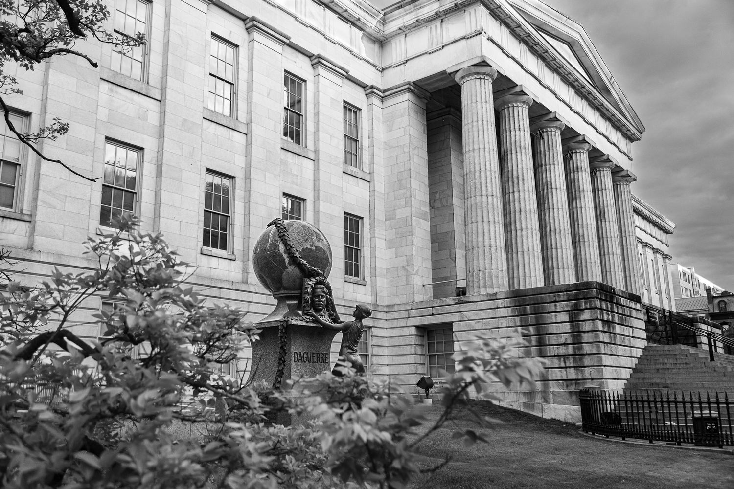 Black and white view of the National Portrait Gallery in Washington DC with classical columns and the Daguerre statue.