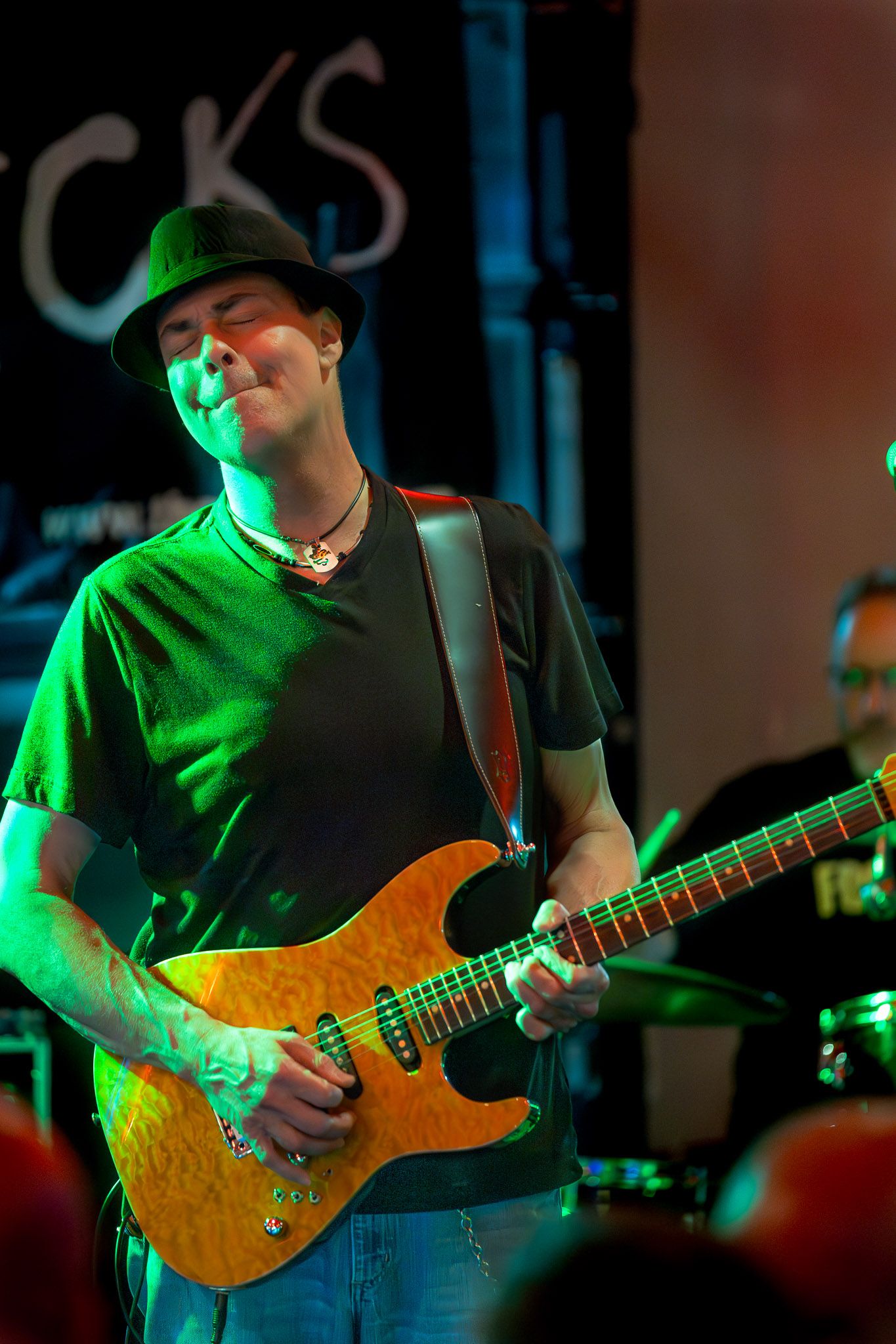 Guitarist performing live with The Wrecks, a New Jersey cover band, at a small venue with dramatic stage lighting