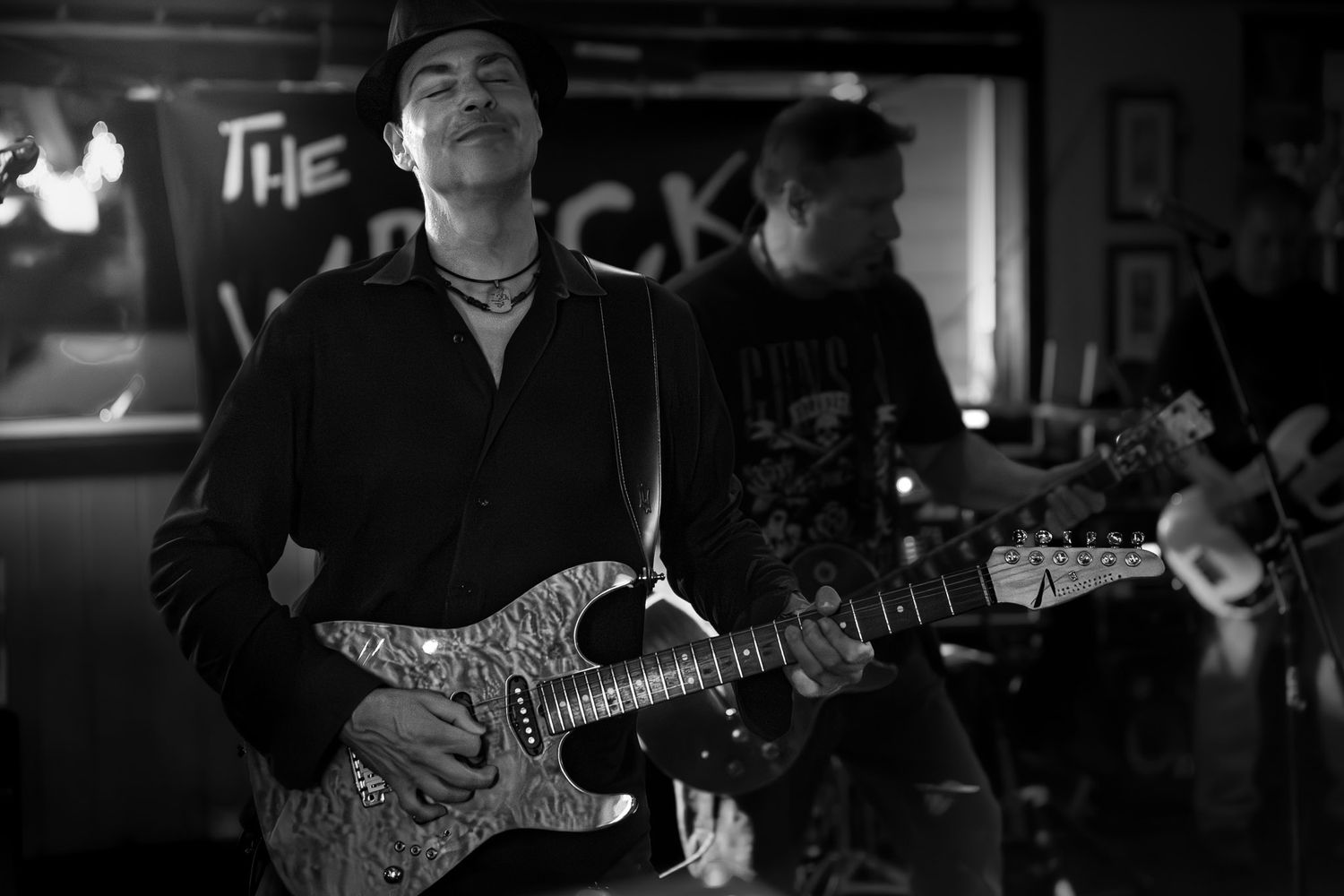 Black and white photo of a guitarist performing live with The Wrecks