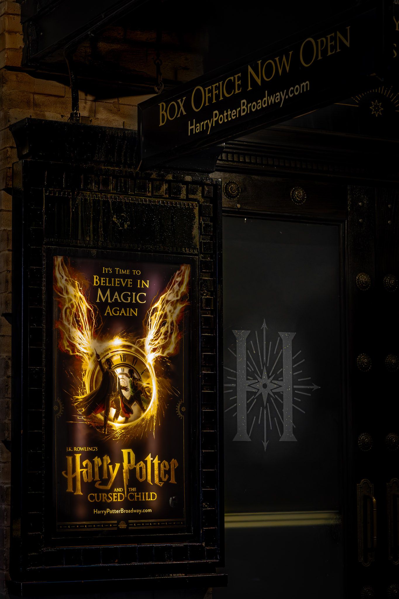 Harry Potter and the Cursed Child theater poster and box office signage in New York City’s Theater District at night.