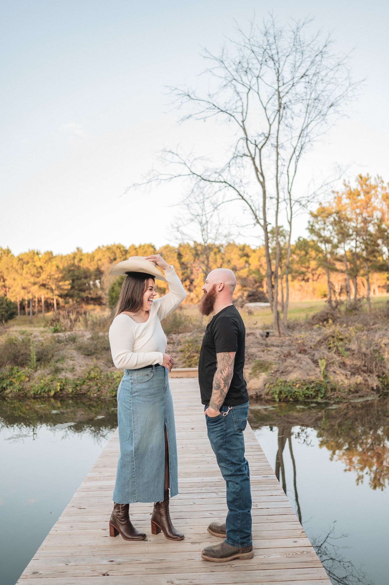 A couple sharing a candid moment on a wooden dock during autumn.