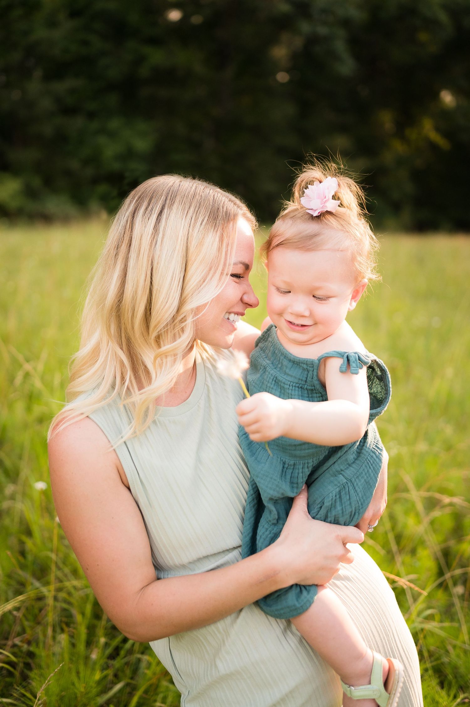 Sweet outdoor photoshoot in a sunny field with soft natural lighting and tall grass.