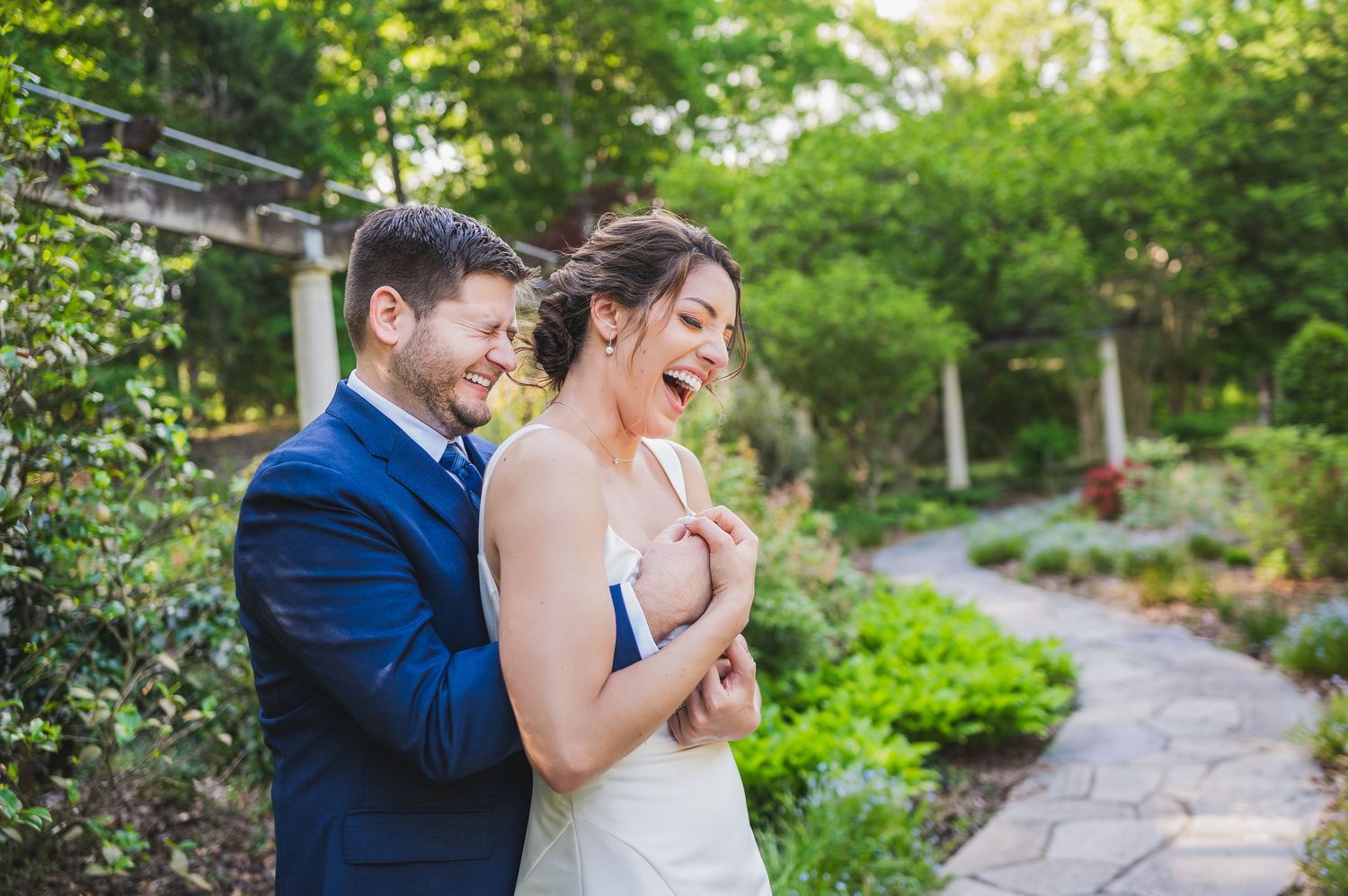 Outdoor garden wedding photography session featuring elegant stone architecture and natural landscaping.