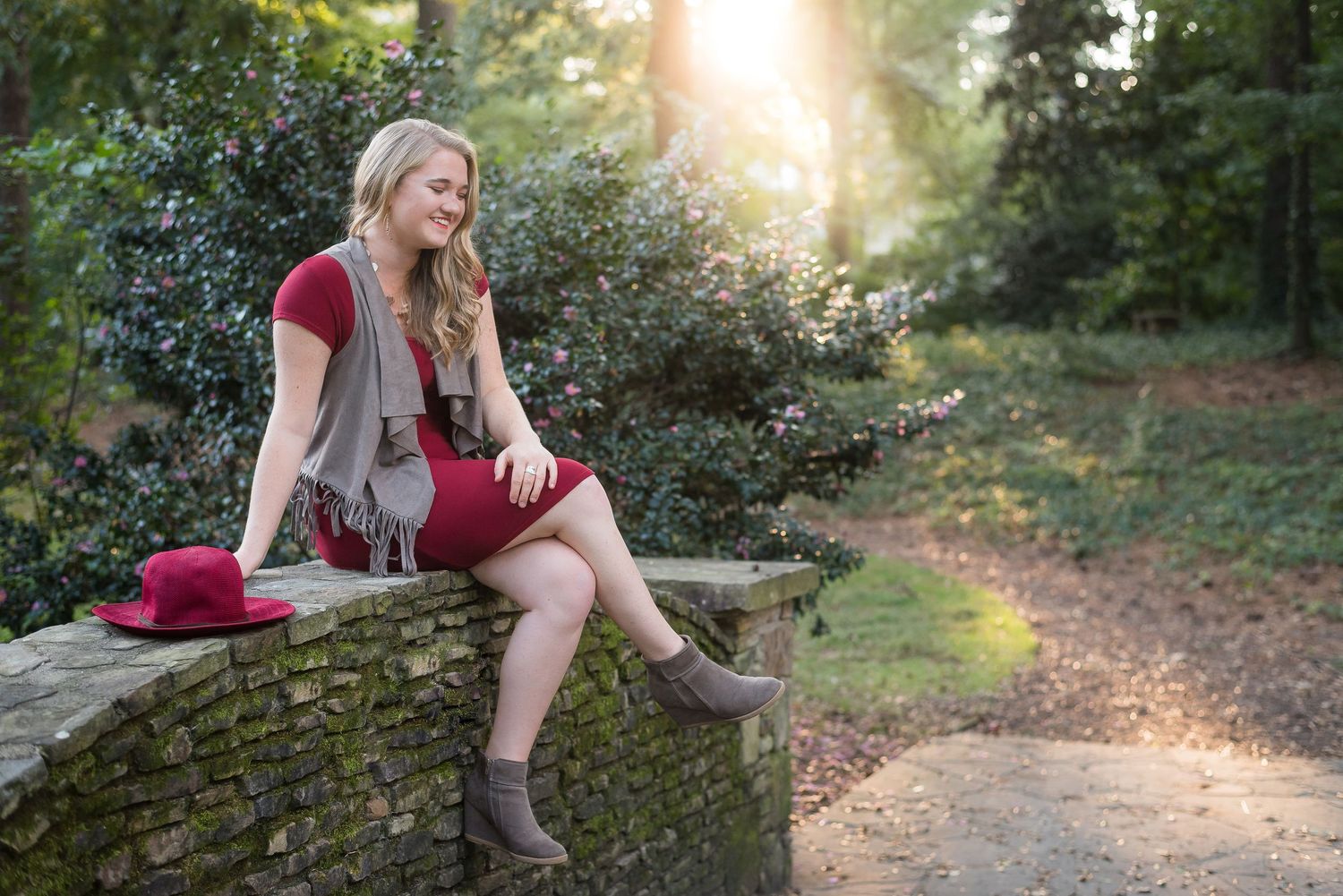 Artistic outdoor portrait session in golden sunlight along a wooded path.