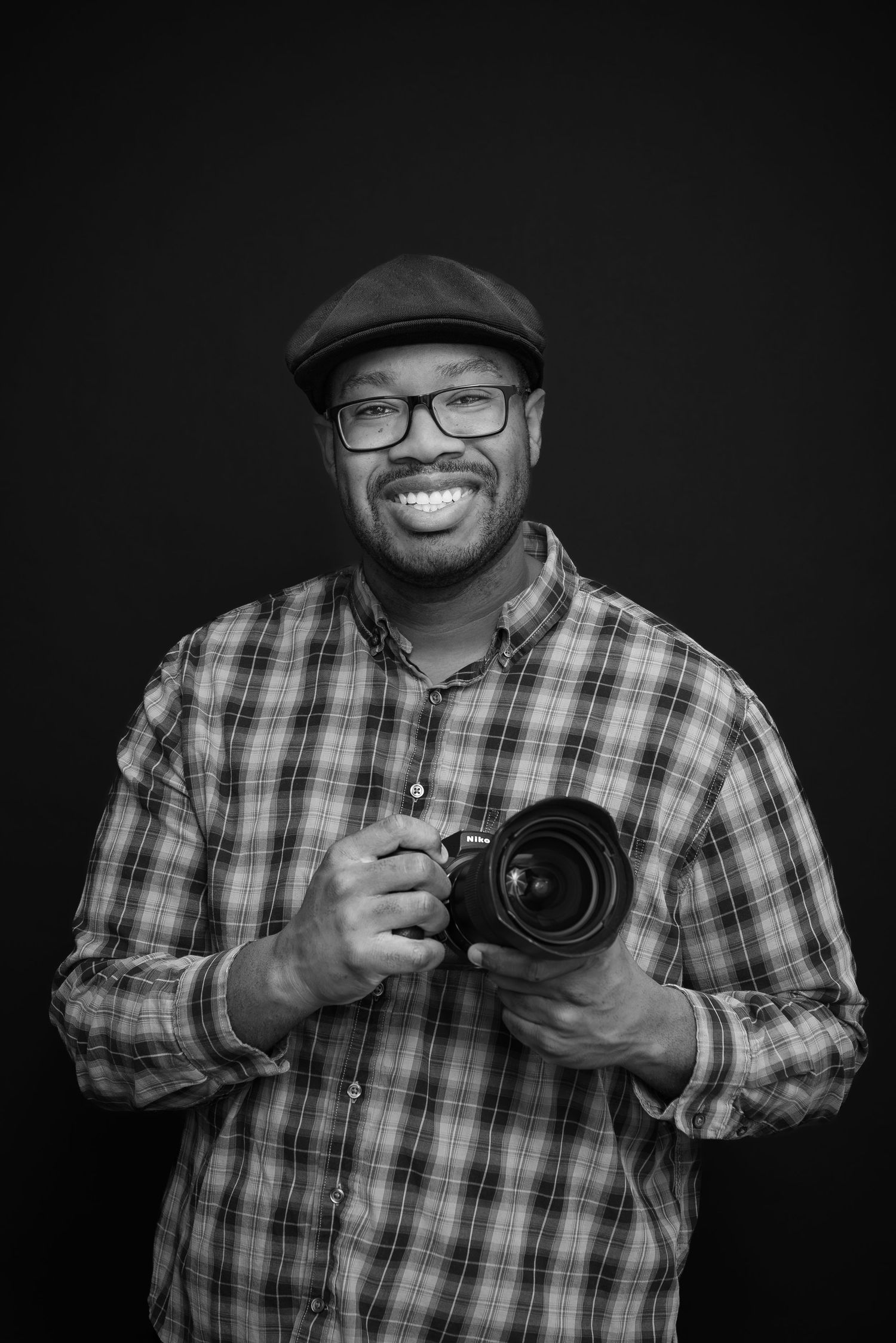 Series of black and white photos showing photographer adjusting camera settings and smiling.