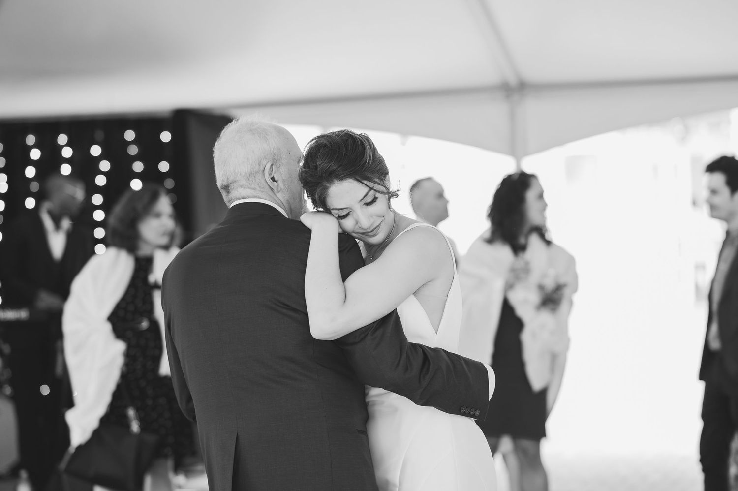 A tender black and white dance moment at an indoor wedding reception.