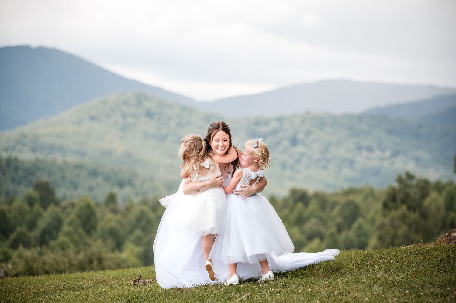 A heartwarming scene with flower girls in white dresses against a mountain backdrop.