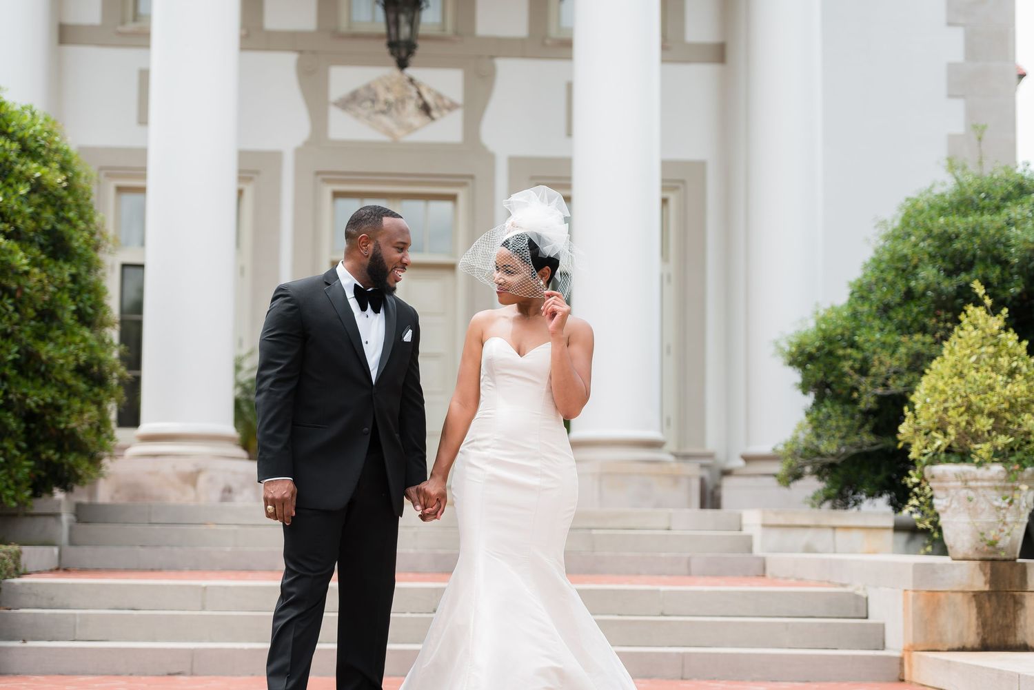Stately wedding venue with white columns and ornate architectural features.