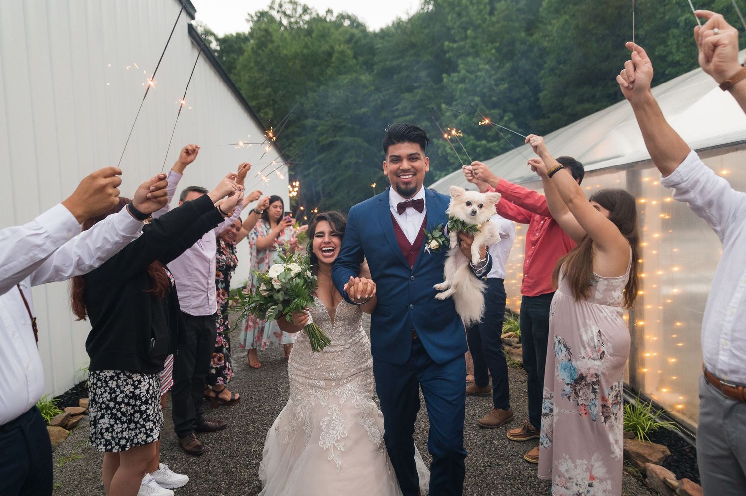 Wedding celebration with guests and couple dancing outdoors under string lights.