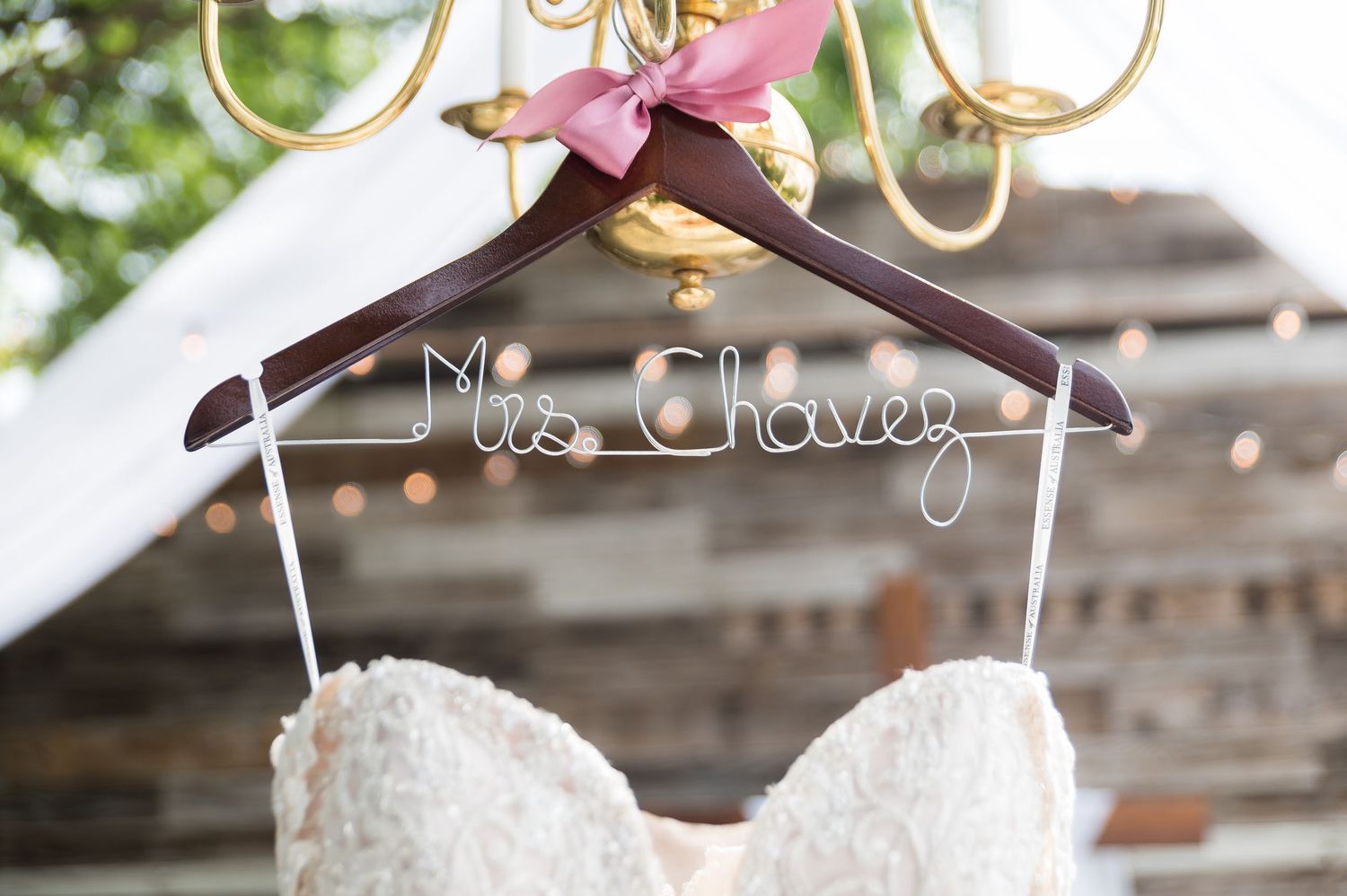 Custom wedding hangers with Mrs engraved text displayed against a rustic backdrop.