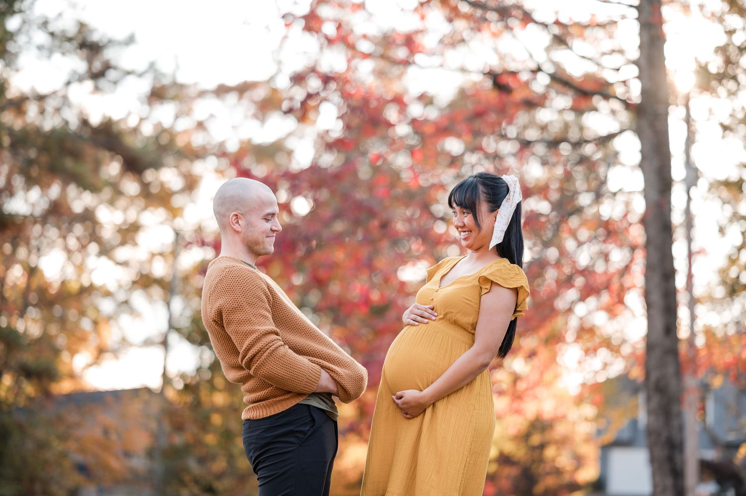 Autumn engagement photoshoot with warm fall colors in a wooded setting.