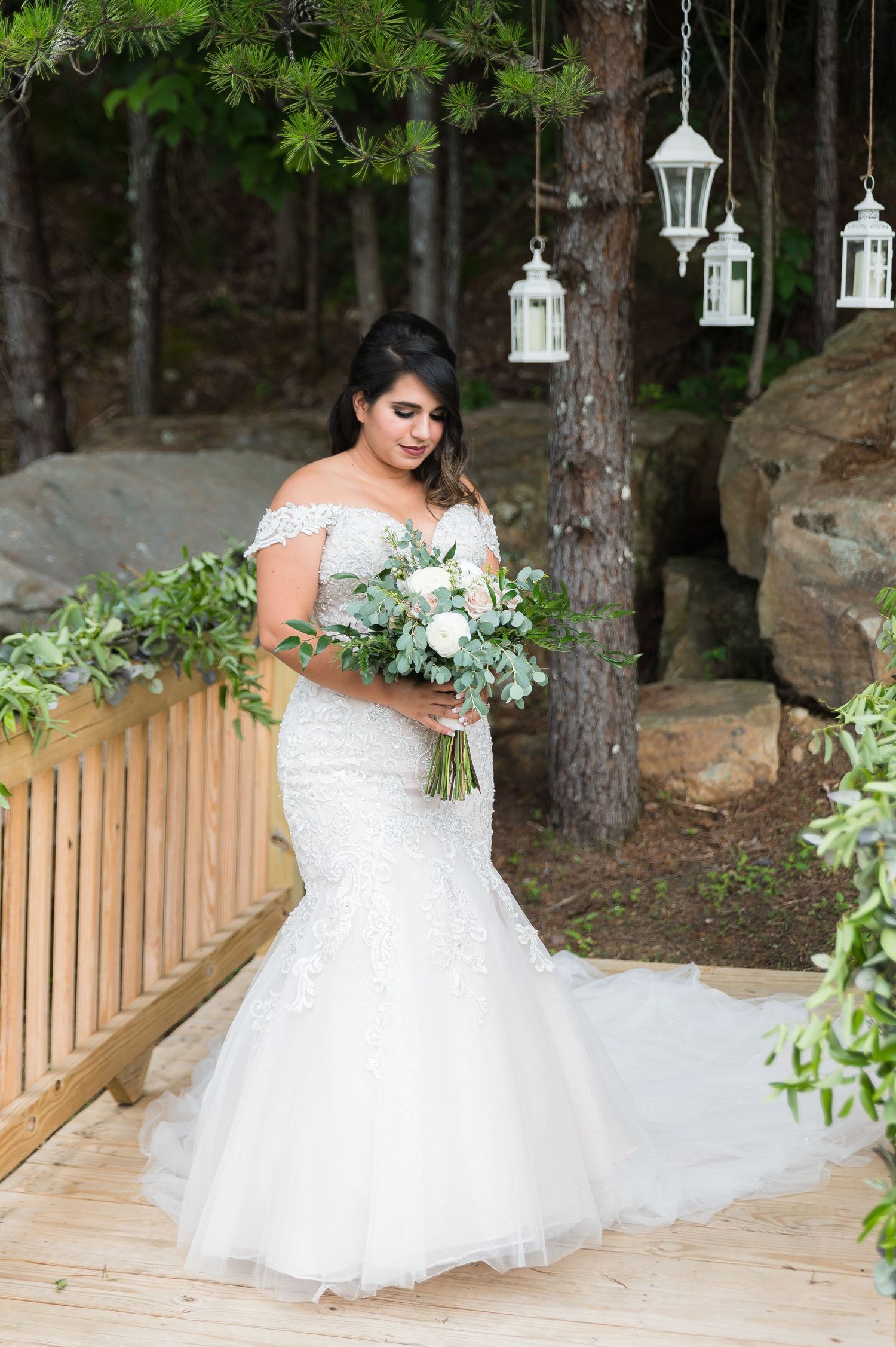 Elegant bridal portraits showcasing a white wedding dress with a flowing train on a wooden deck.