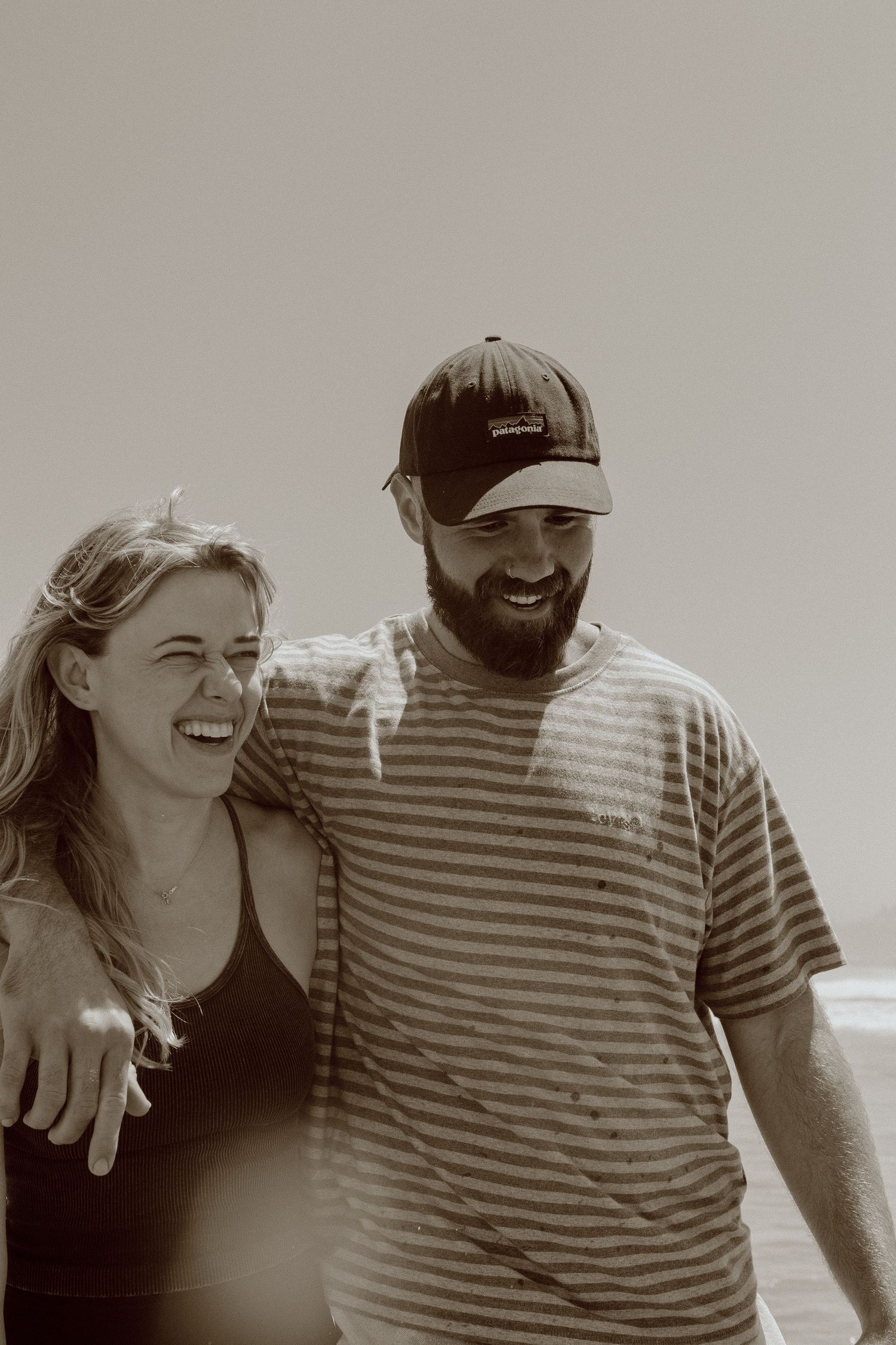A couple laughs together in a sequence of black and white candid photos showing natural, joyful moments.