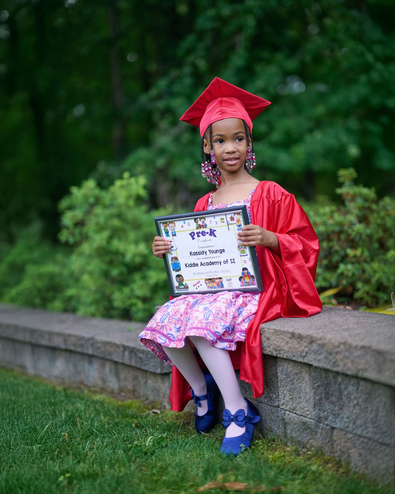 Playful graduation photos showing diploma display in red cap and gown.
