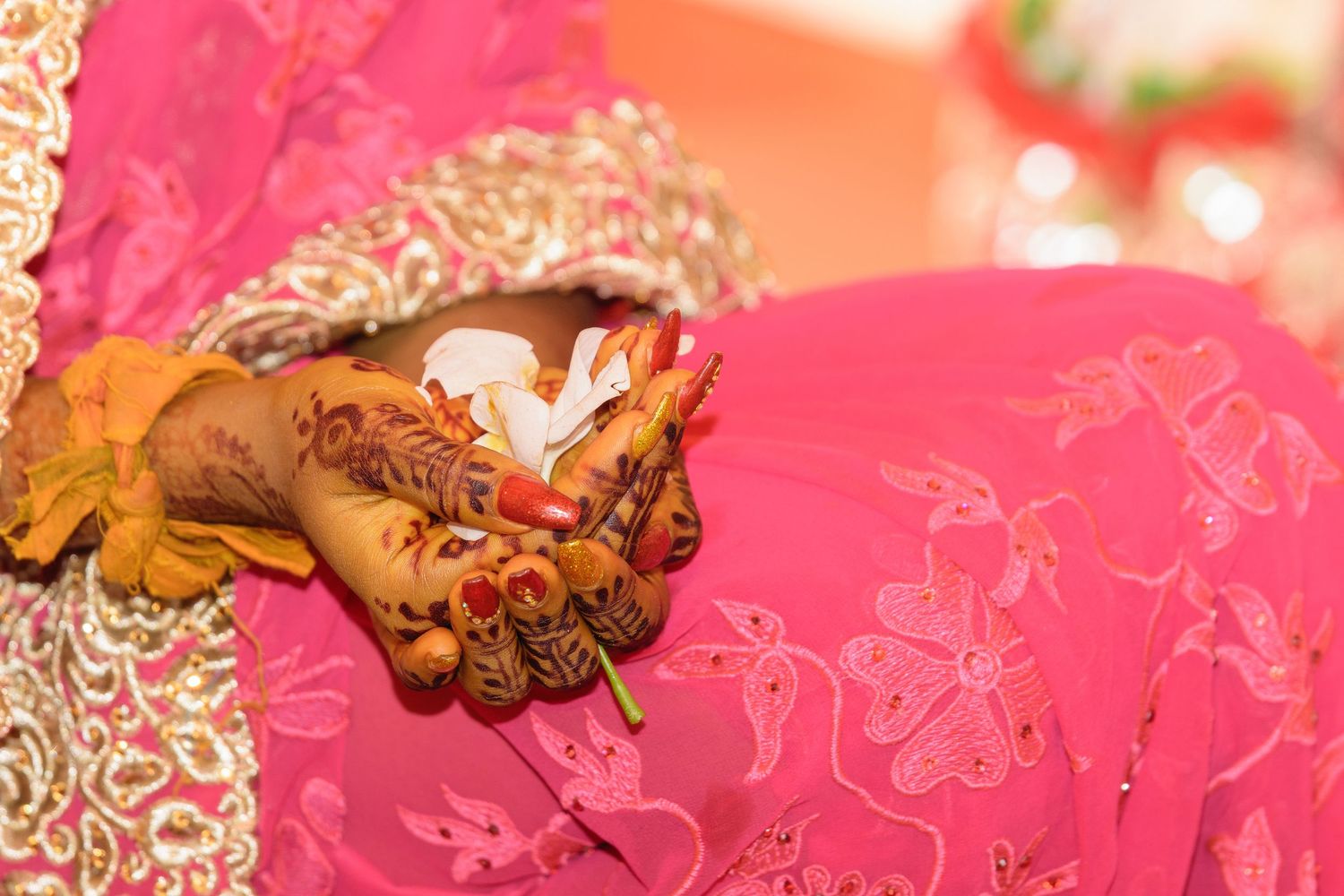 Artistic detail shots of wedding ceremony elements with pink and orange lighting.