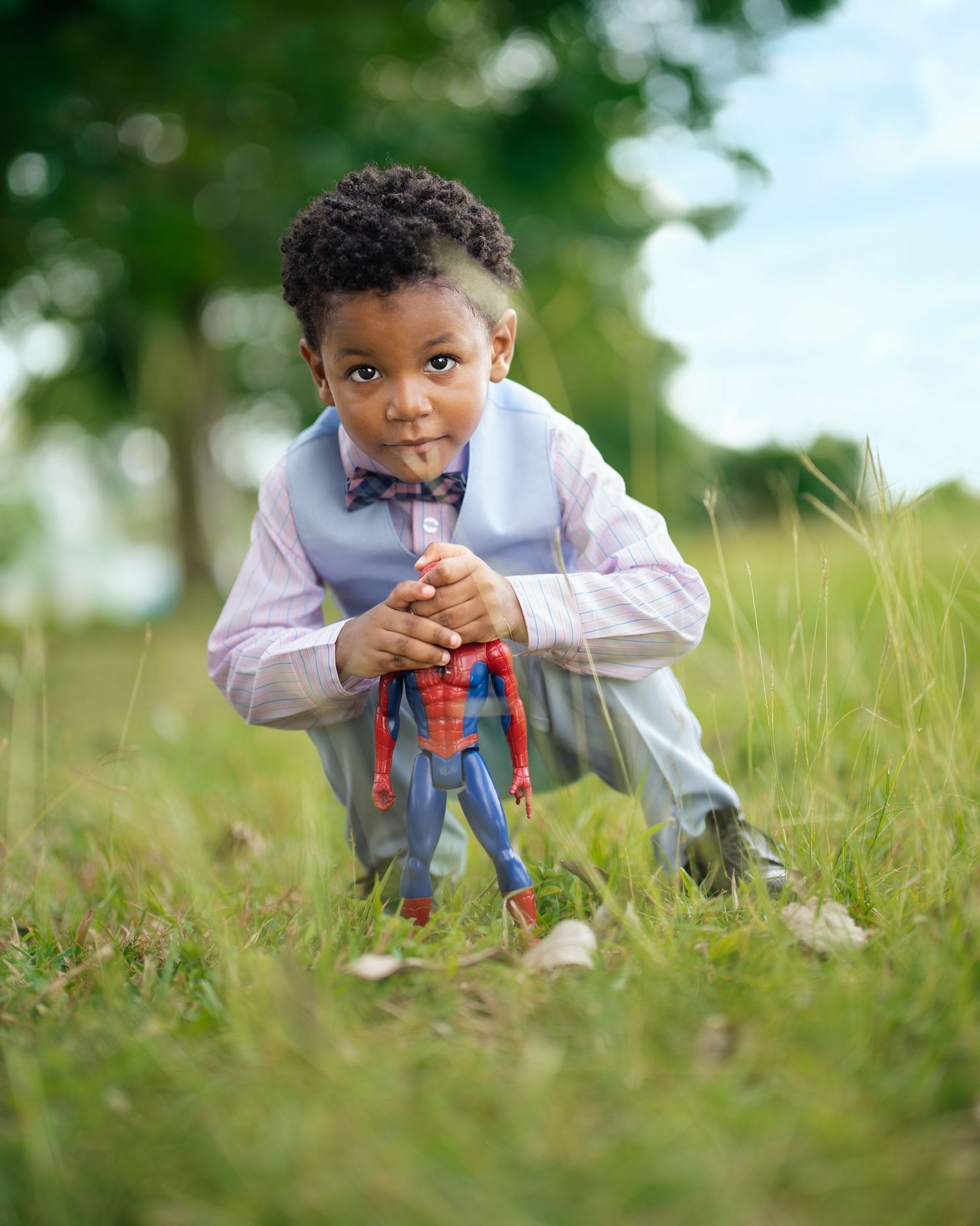 Child playing in tall grass wearing light colored clothing.