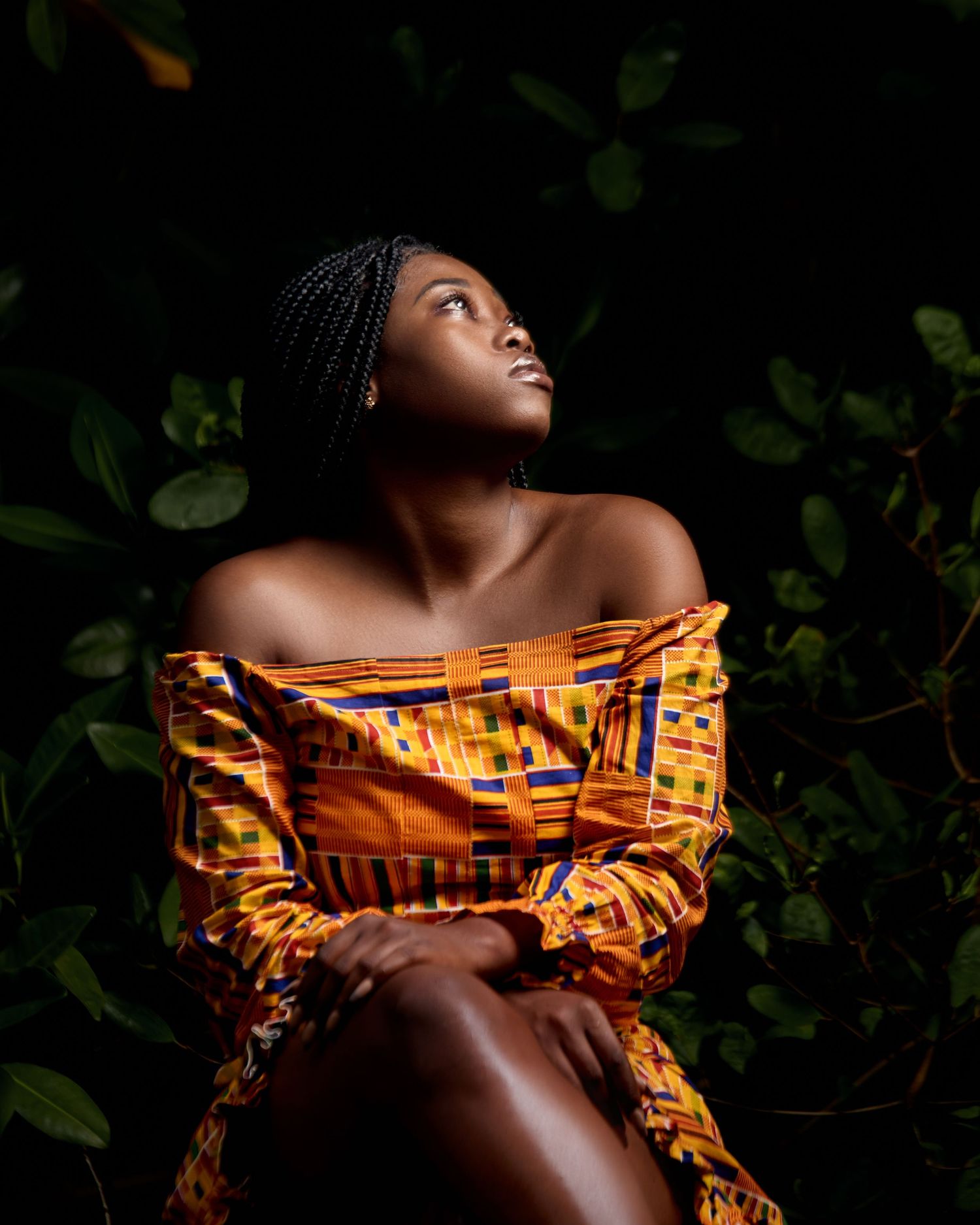 Moody portrait with dramatic lighting featuring an orange patterned fabric.