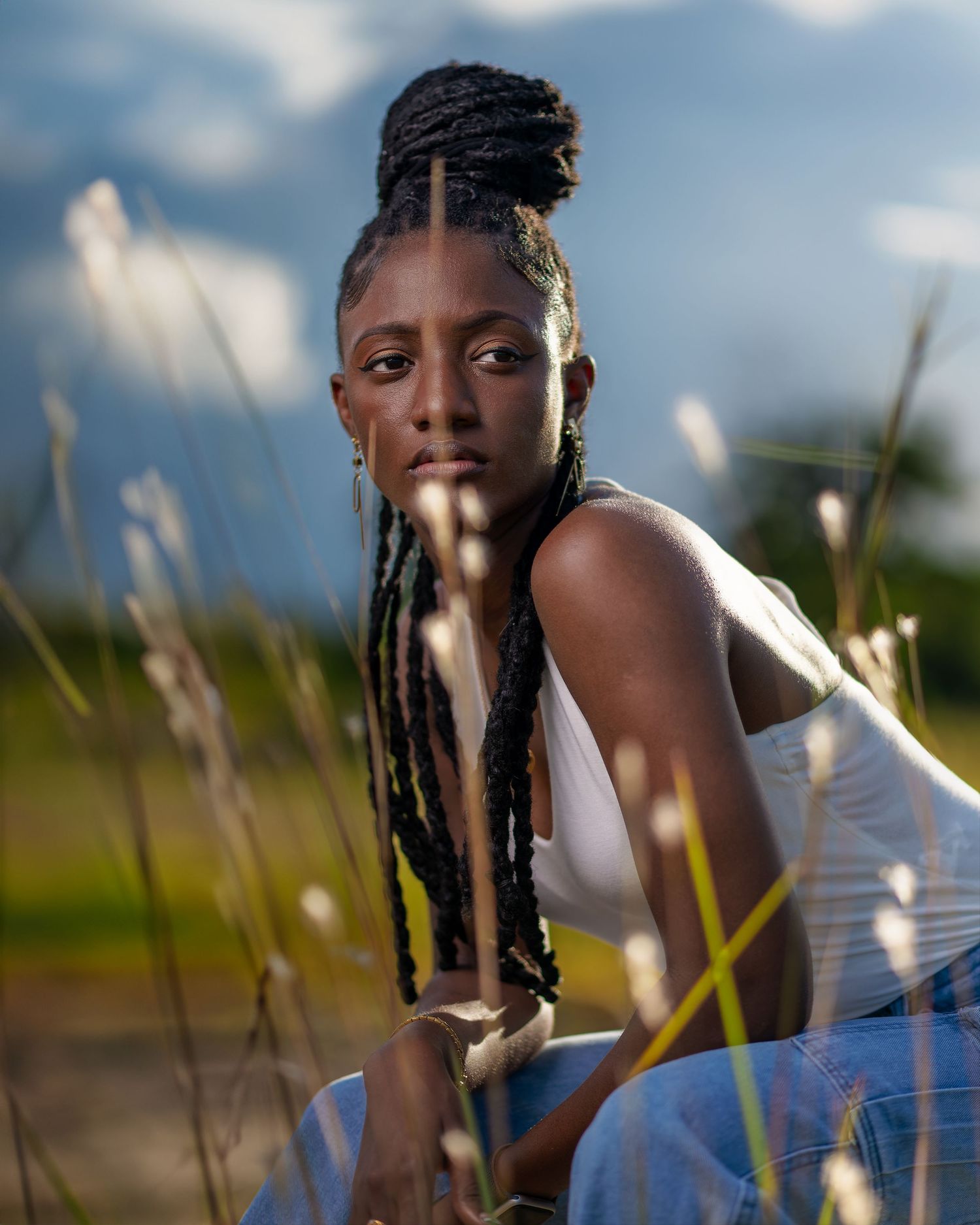 Portrait session in tall grass during golden hour with soft natural lighting.