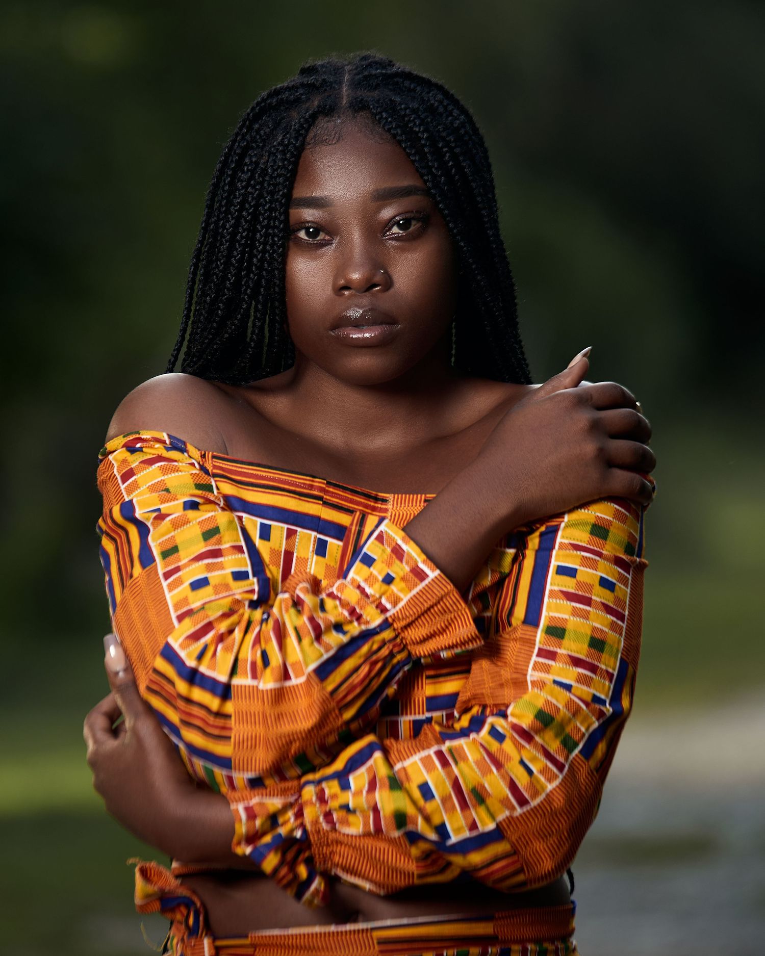 Artistic portrait featuring traditional African print clothing in warm earth tones.