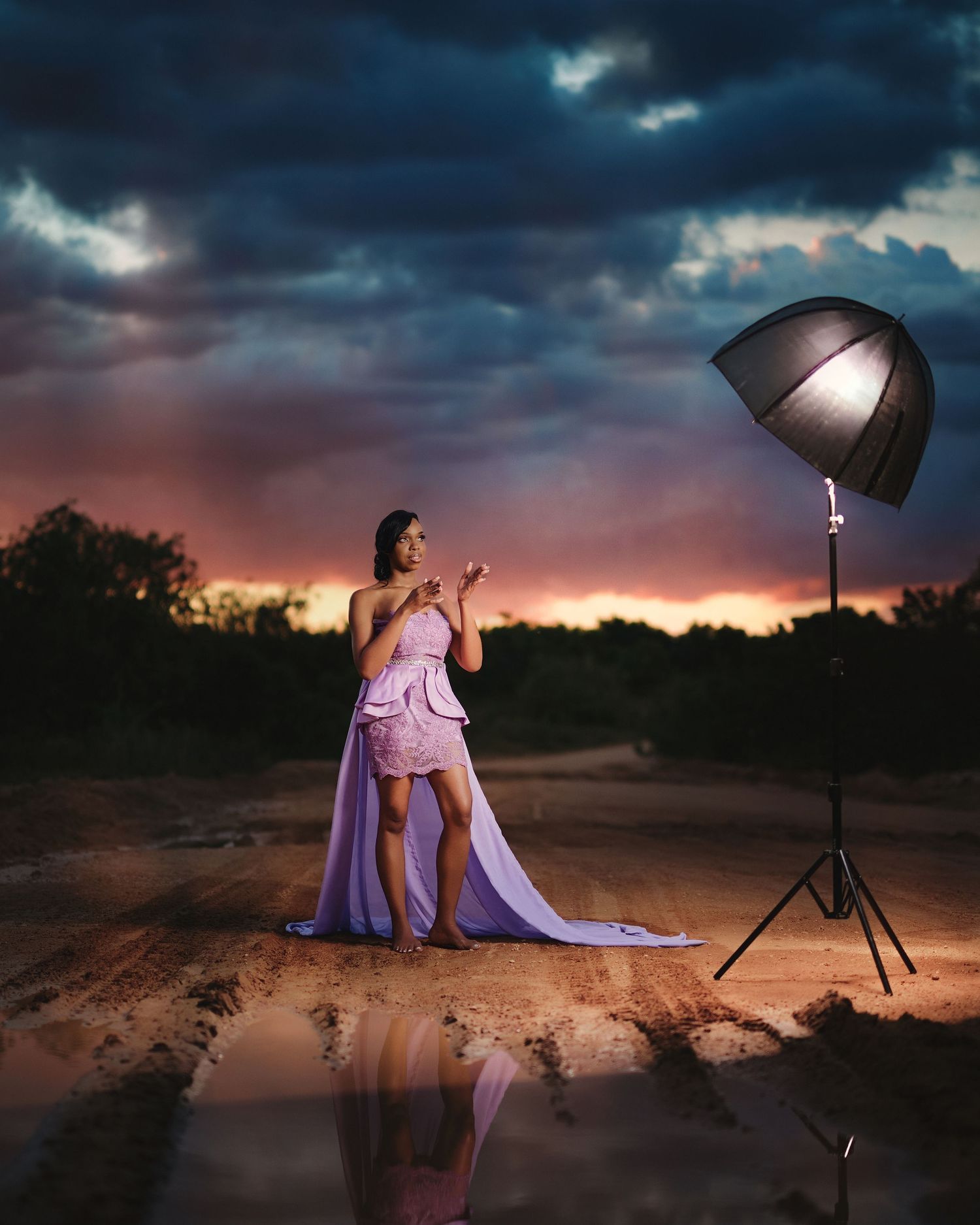 Dramatic sunset photoshoot in desert setting with professional lighting equipment.