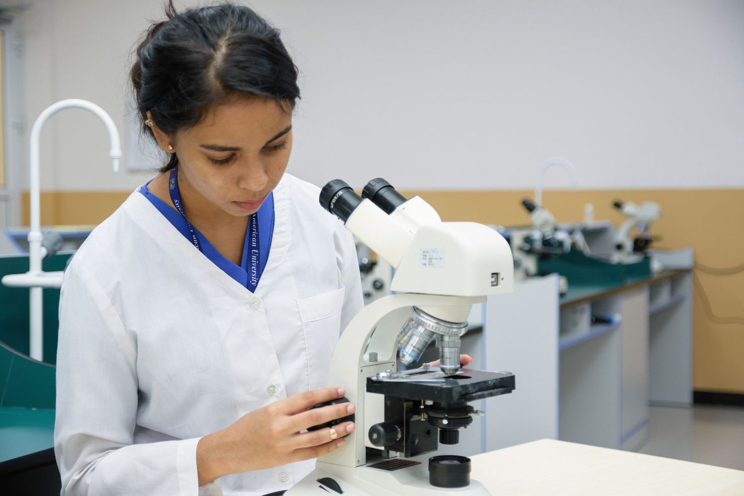 Scientists examining specimens under microscopes in a medical research laboratory.