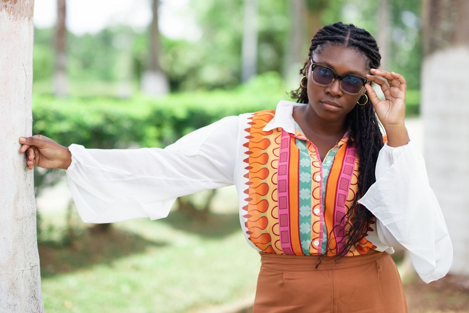 Colorful patterned outfit with white sleeves photographed in garden setting.