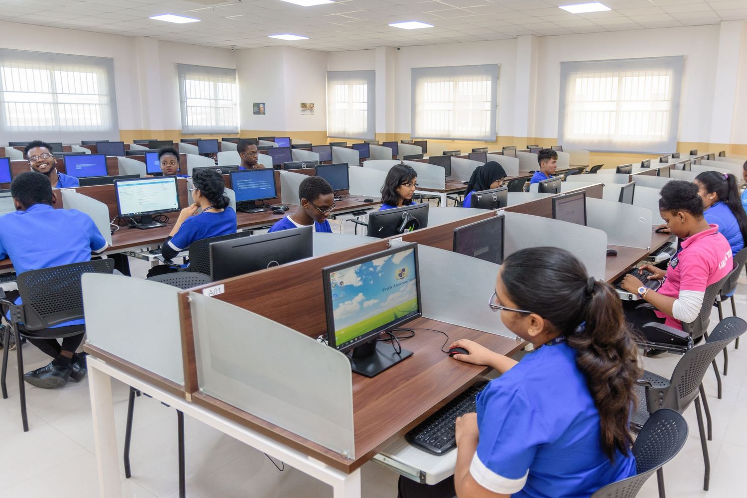 Students working at computer stations in a spacious educational facility.