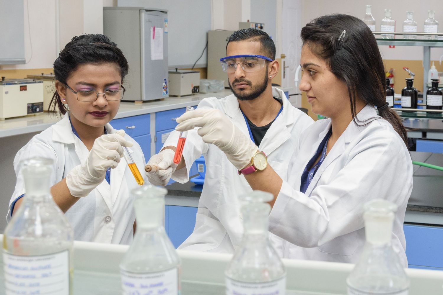 Scientists in white lab coats conducting research with laboratory equipment.