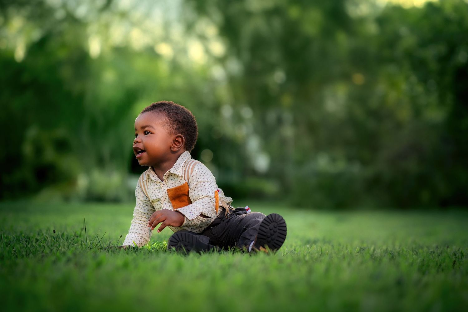 Child laying on grass in natural outdoor setting.