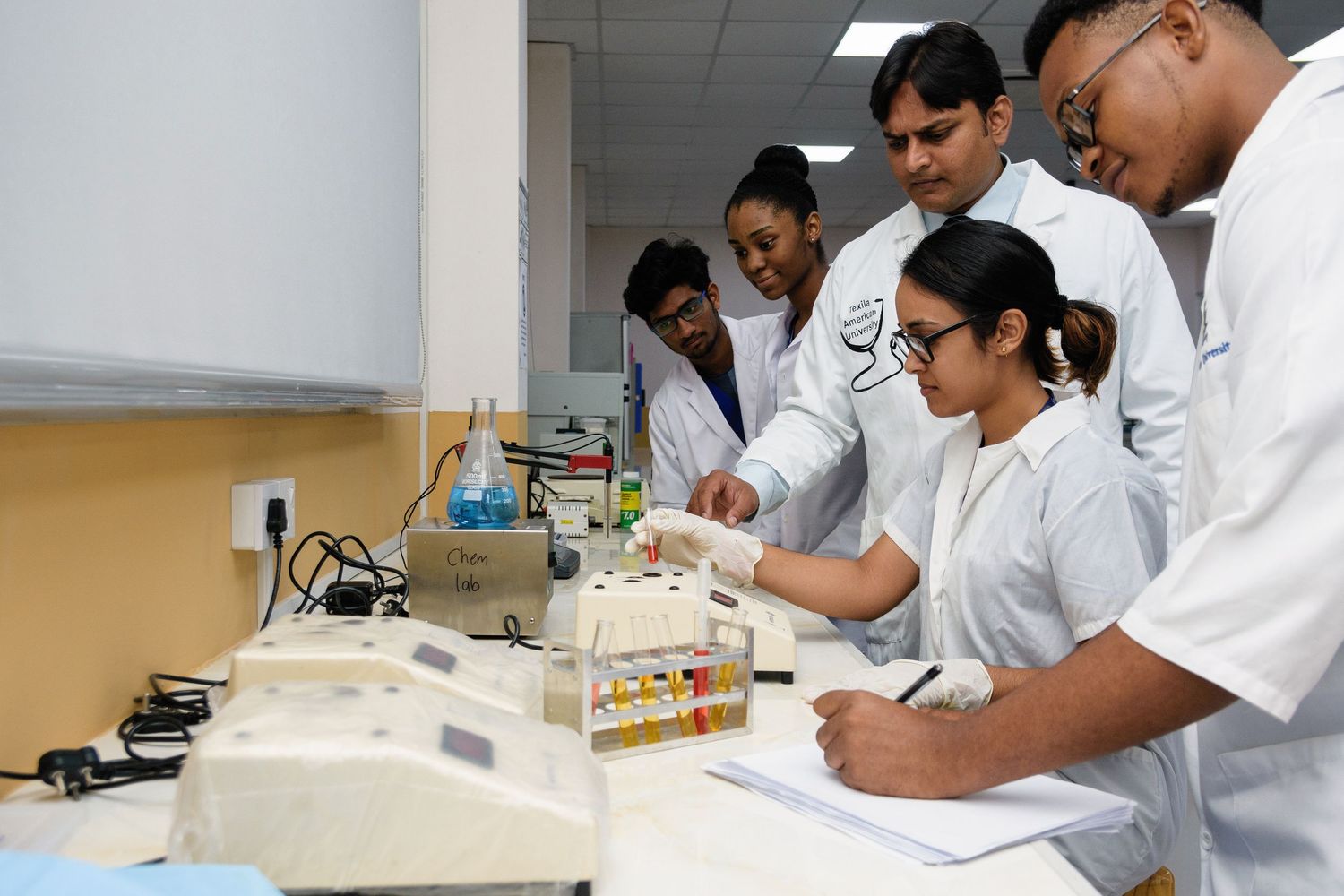 Scientists conducting experiments and analyzing samples in a modern laboratory setting.