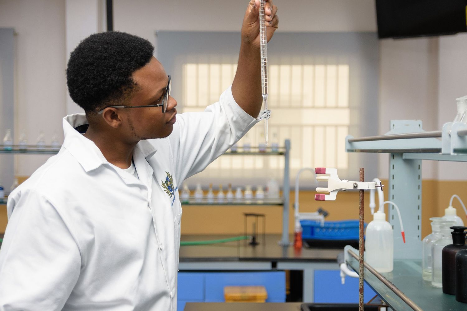 Scientists working with laboratory glassware and conducting experiments at research benches.