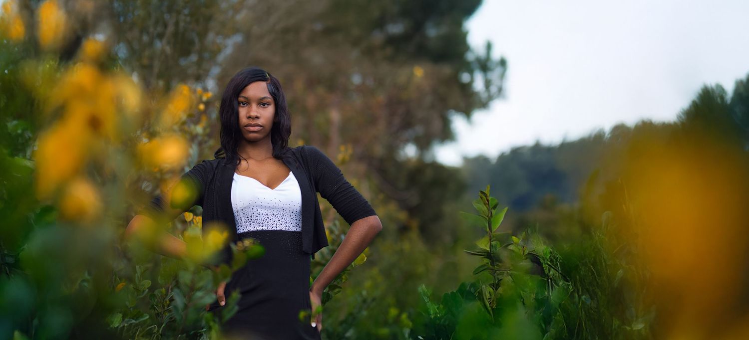 Autumn outdoor photoshoot in a natural setting with yellow flowers and greenery.