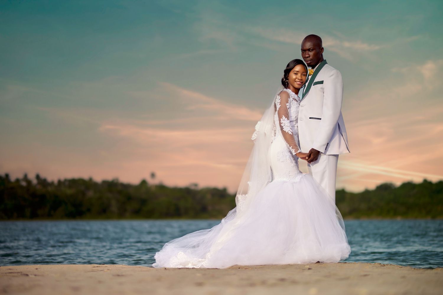 Romantic sunset beach portrait with couple embracing by waterfront.