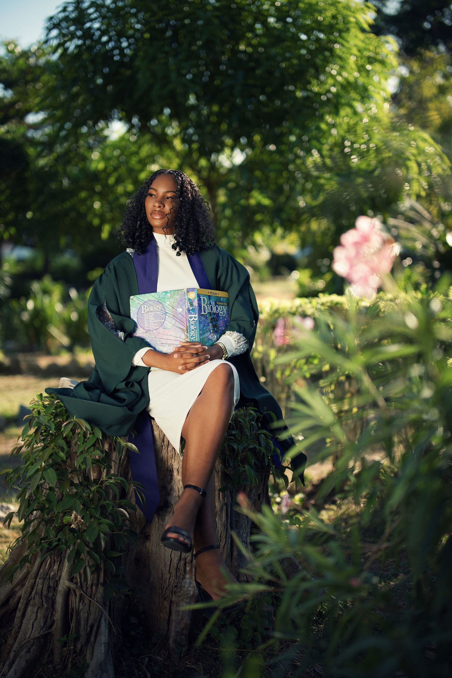 Graduation photos taken in lush garden setting with natural lighting and flowers.