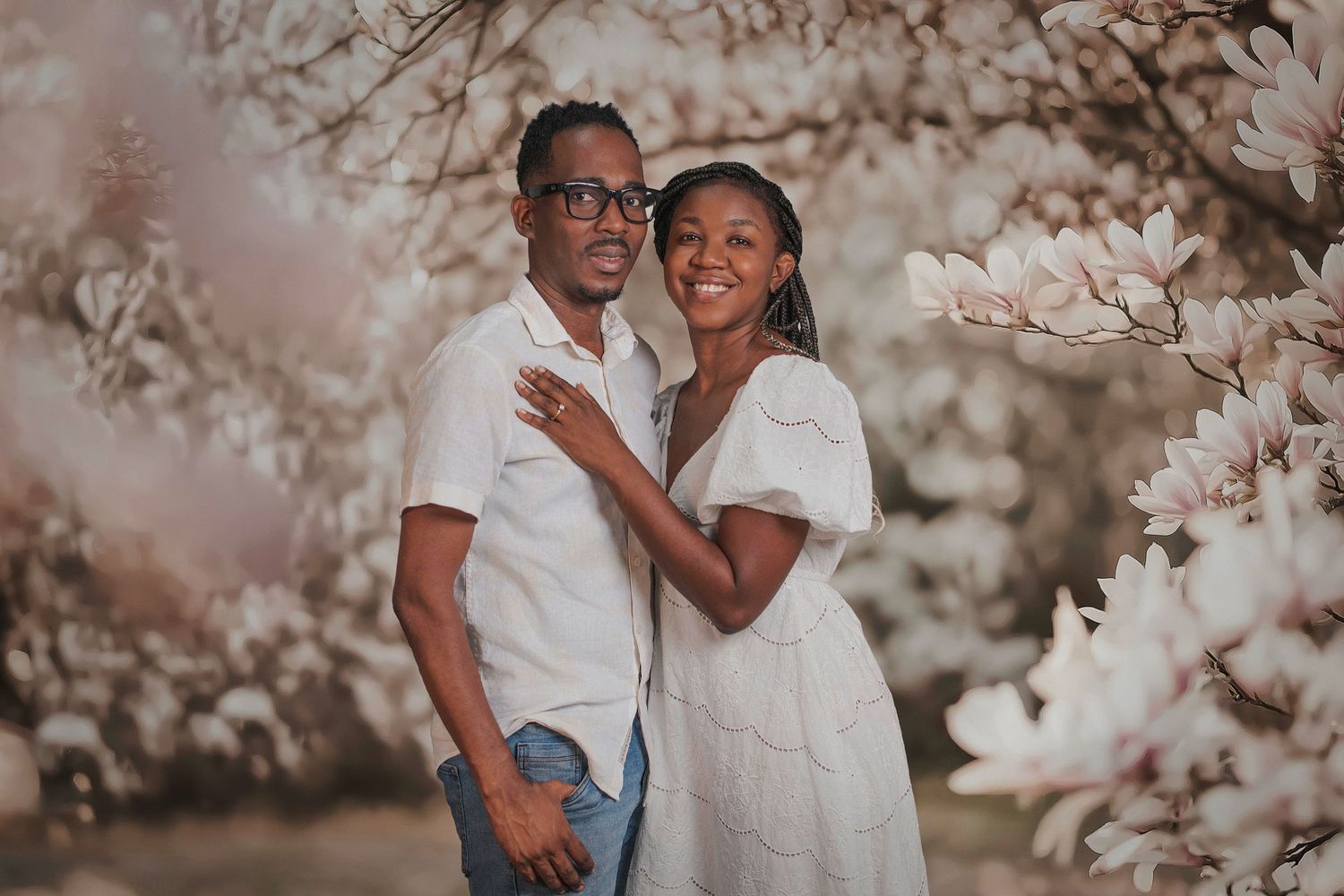 A couple shares romantic moments in a garden with cherry blossoms blooming in the background.